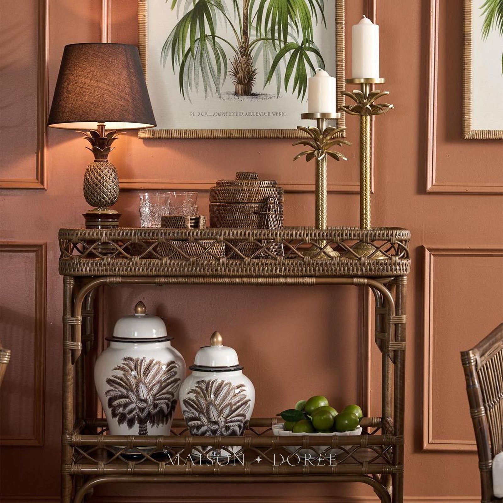 Pineapple table lamp glowing on a brass bar cart against a terracotta wall